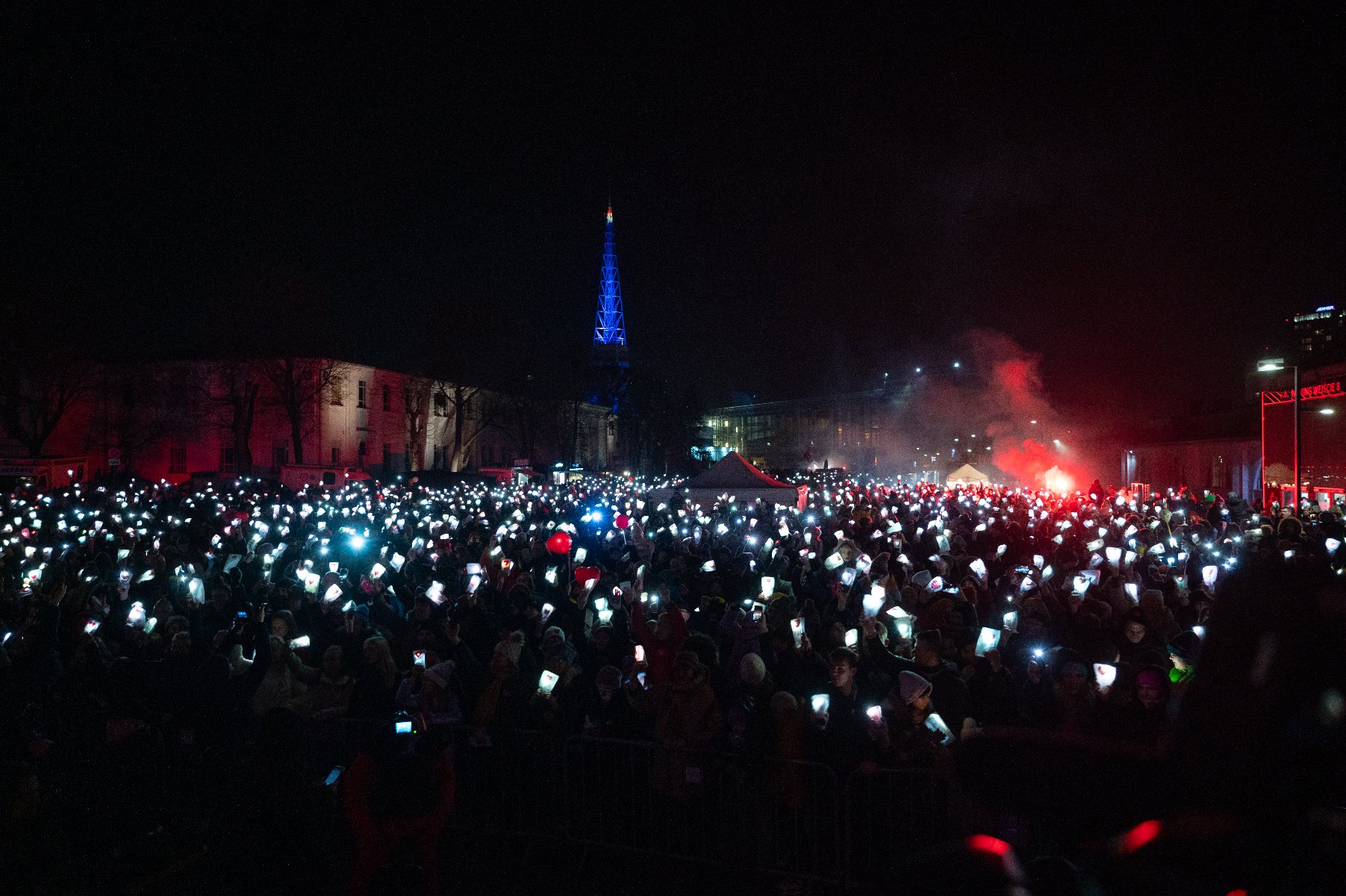 Rozświetlony tysiącami latarek plac PKW na terenie MTP - grafika rozmowy