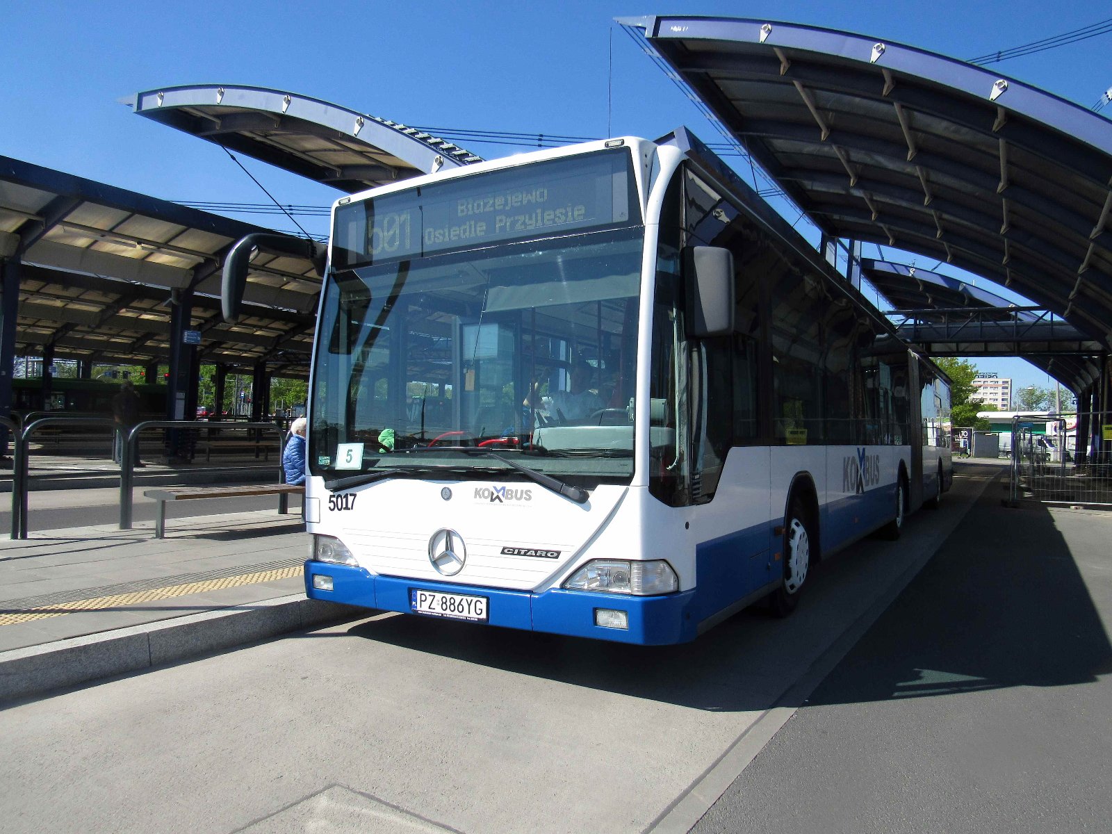 Zdjęcie przedstawia autobus podmiejski na przystanku. - grafika rozmowy