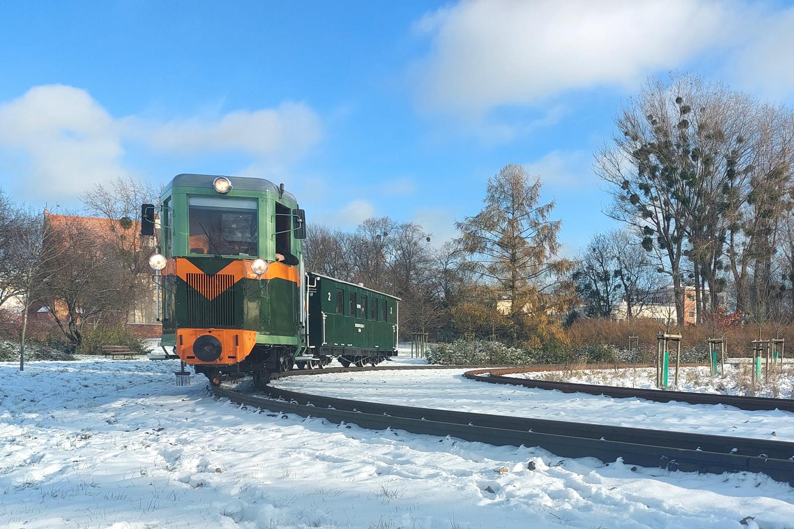 Ryjek ciągnący wagon na łuku torowiska. Dookoła śnieg. - grafika rozmowy