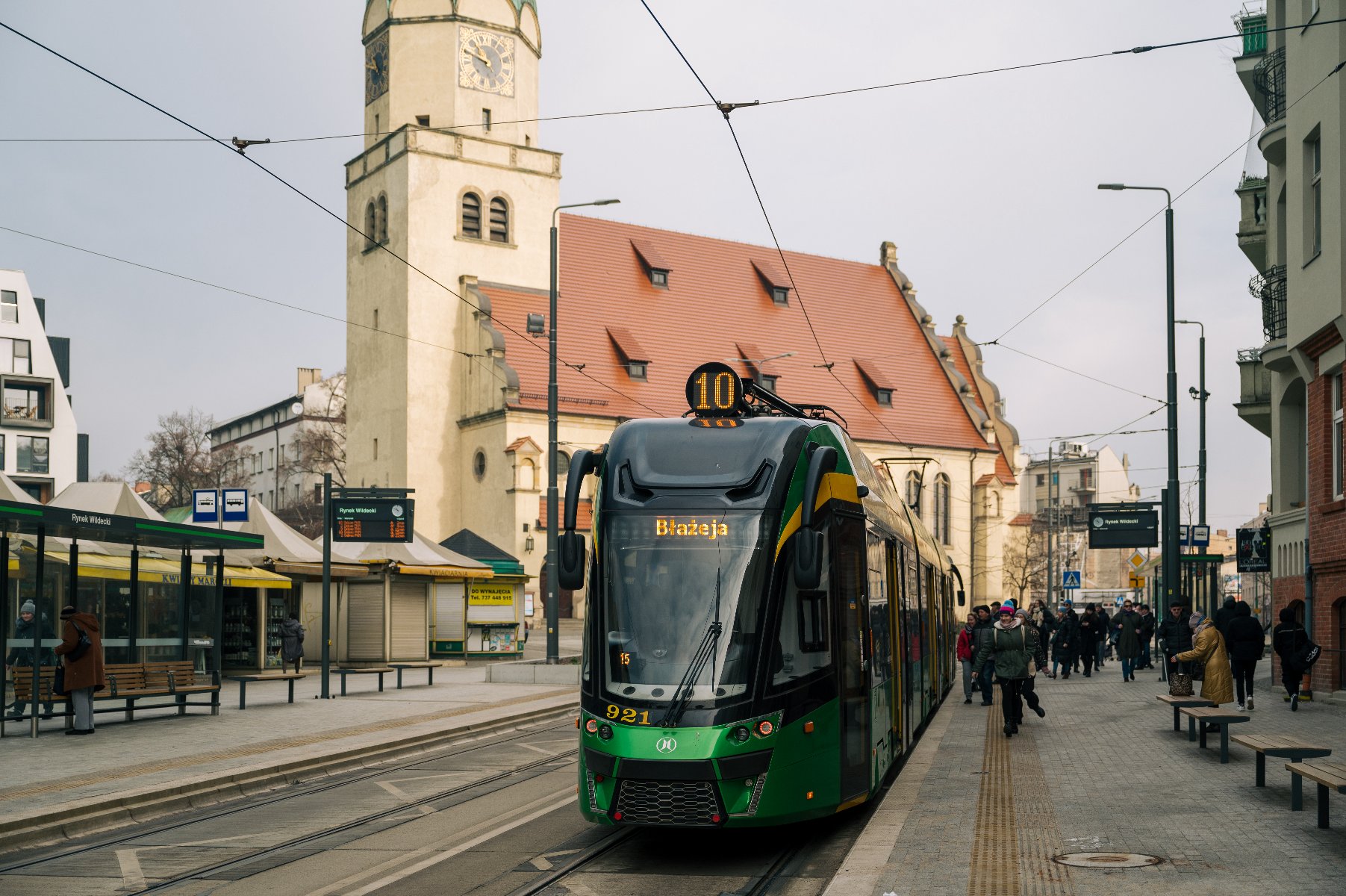 Na zdjęciu tramwaj stojący na przystanku w centrum miasta - grafika rozmowy