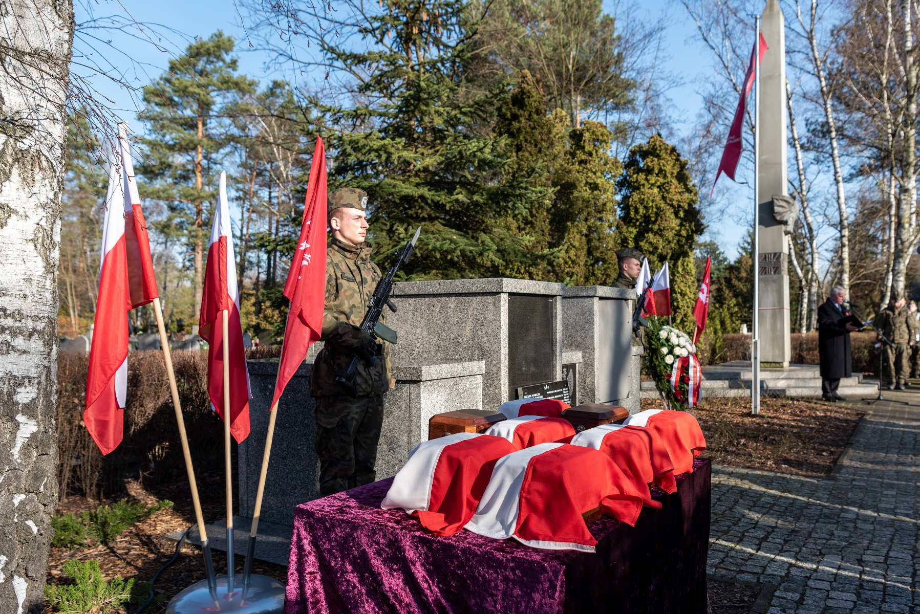 Na zdjęciu urny Powstańców, przy nich żołnierze na warcie - grafika rozmowy