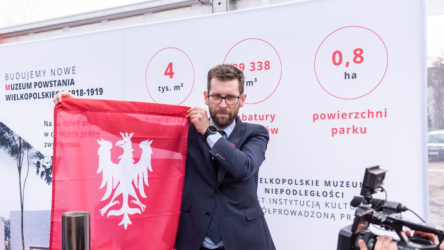 Na zdjęciu mężczyzna trzymający flagę Powstania Wielkopolskiego