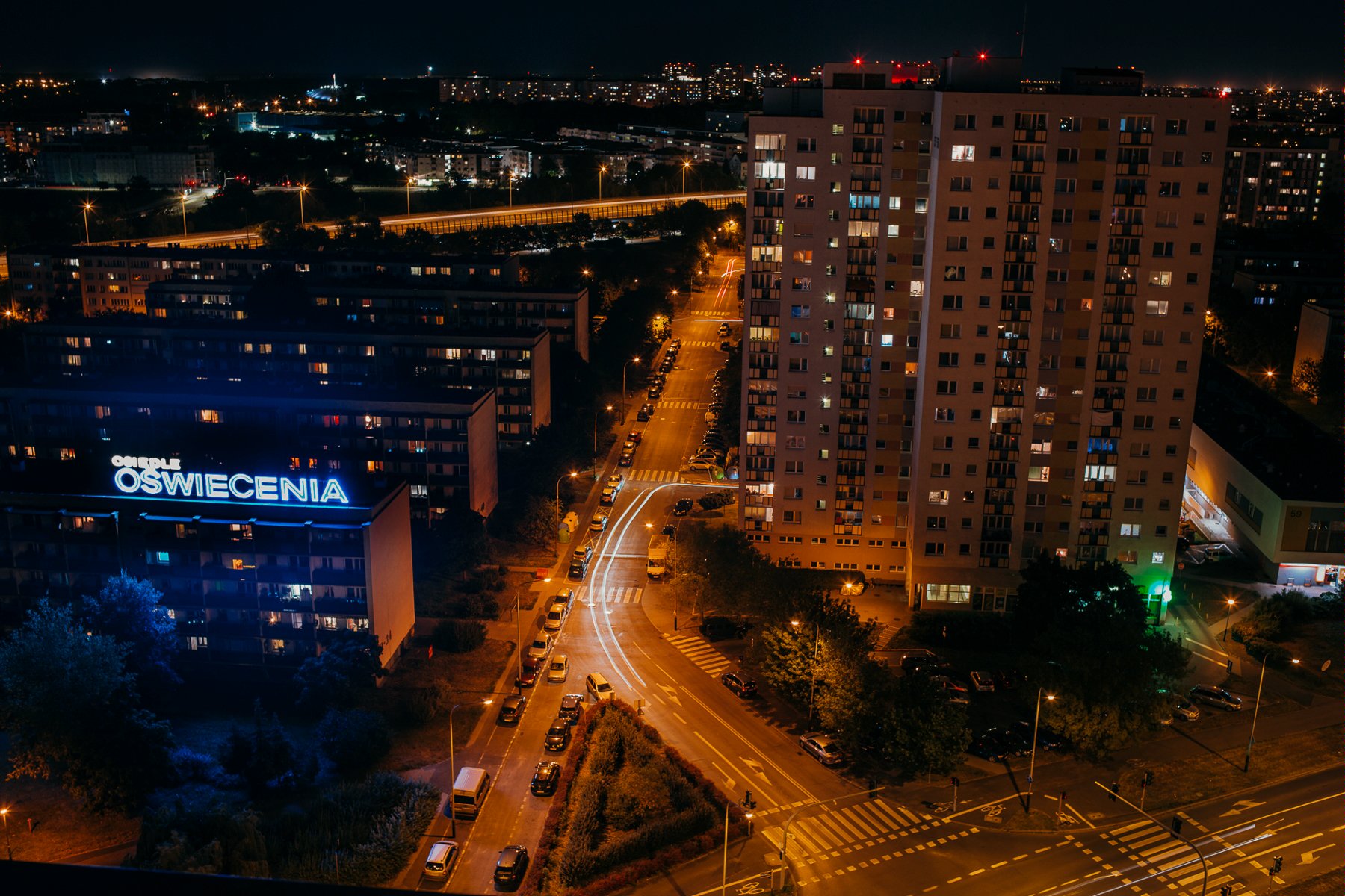 Zdjęcie przedstawia bloki na Ratajach widziane z lotu ptaka nocą. - grafika rozmowy