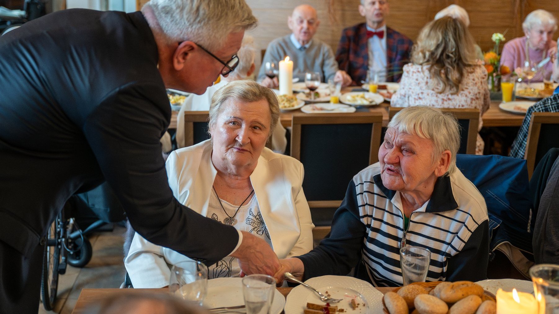 Na zdjęciu prezydent Poznania rozmawiający z dwiema kobietami za stołem