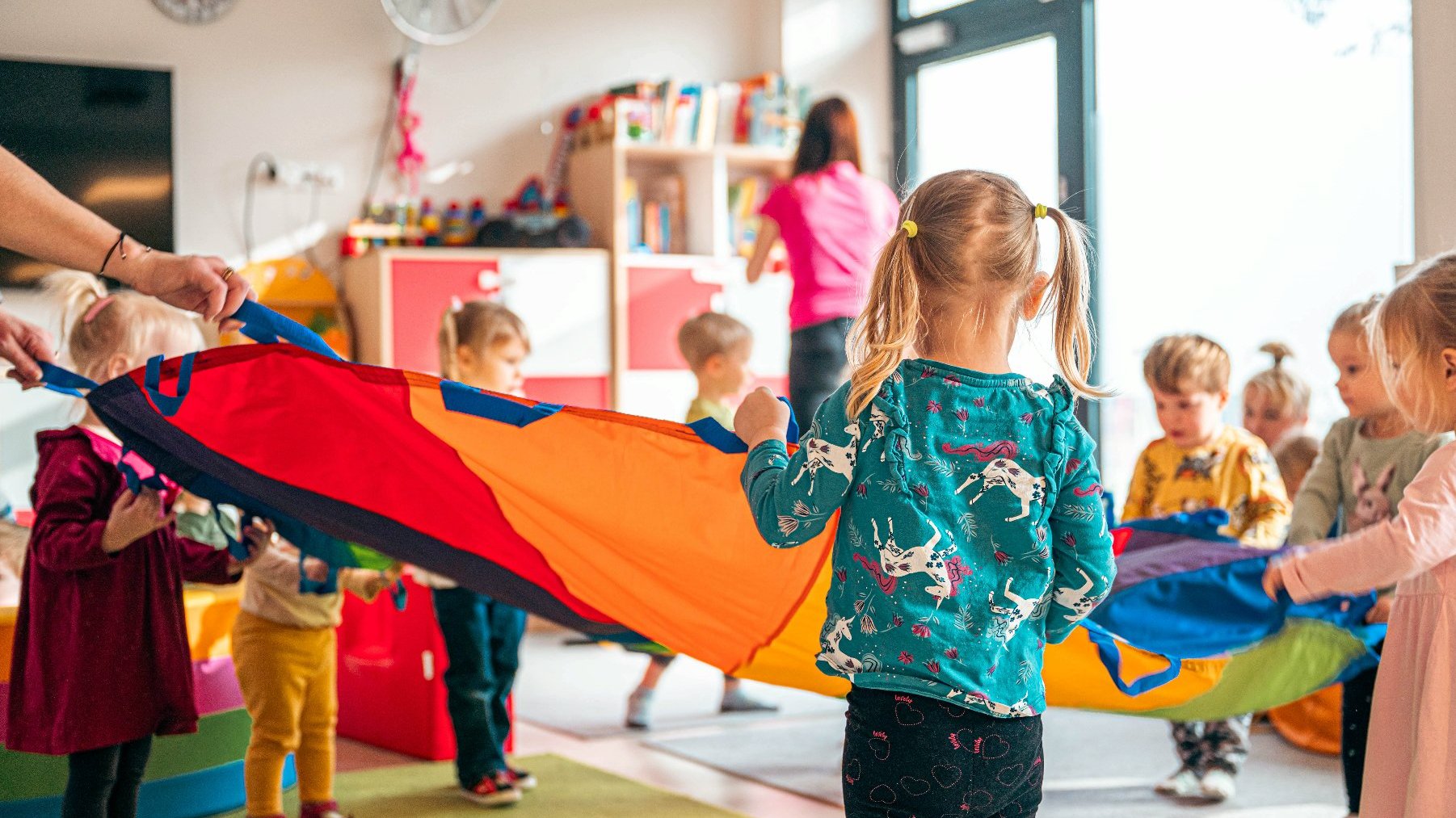 Zdjęcie przedstawia dzieci bawiące się chustą klanza.