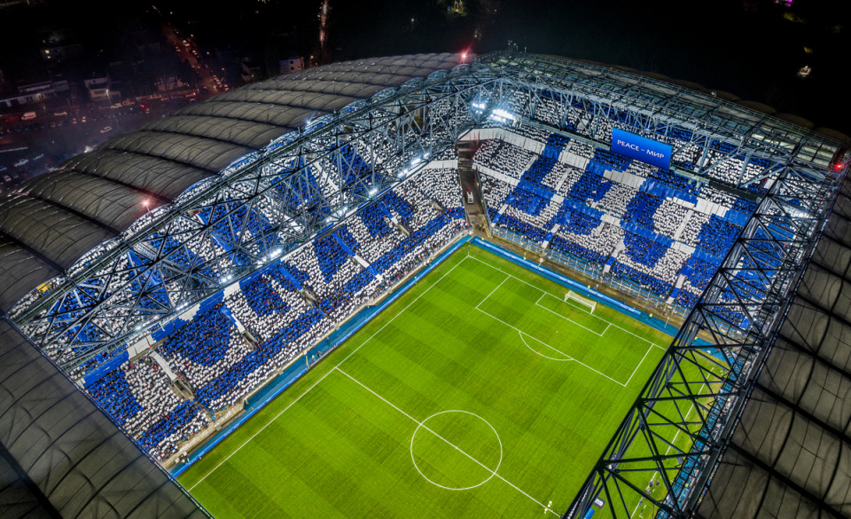 Widok na stadion przy Bułgarskiej z drona. Na trybunach widać napis "Forza Lech" - grafika rozmowy