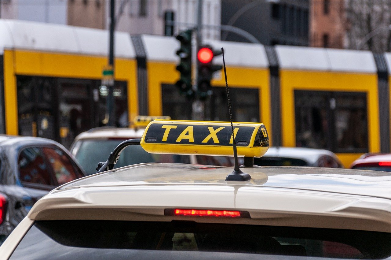 Zdjęcie przedstawia znak taxi umieszczony na dachu samochodu. - grafika rozmowy