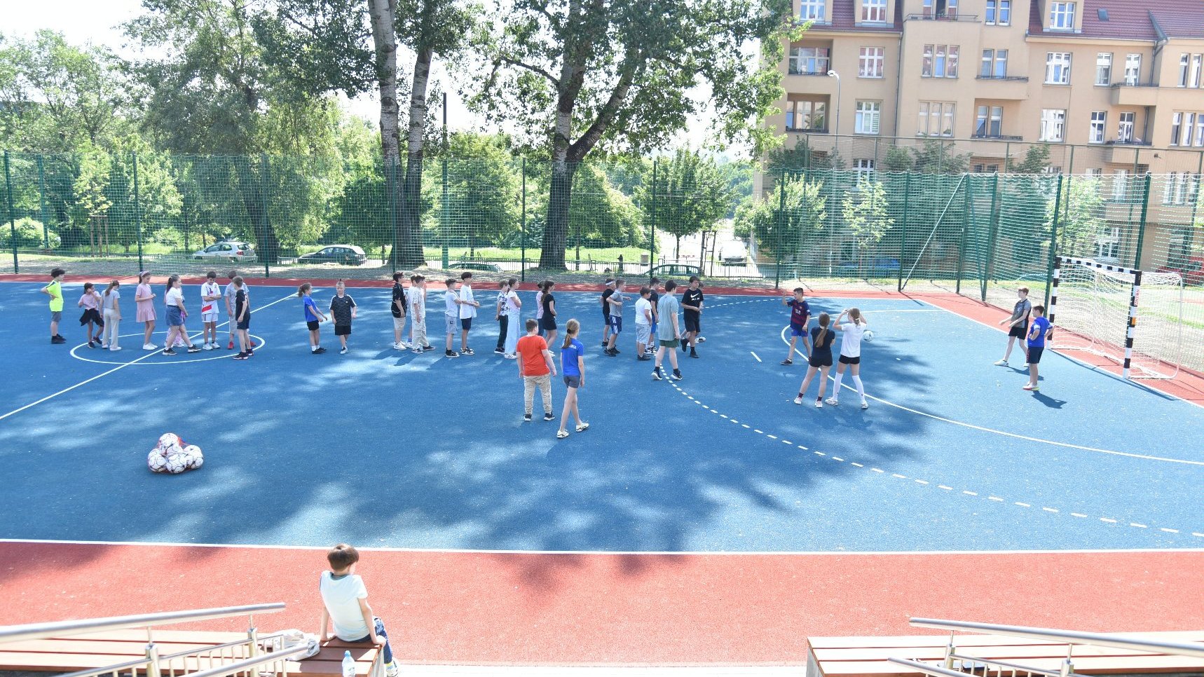 Zdjęcie przedstawia dzieci na boisku.