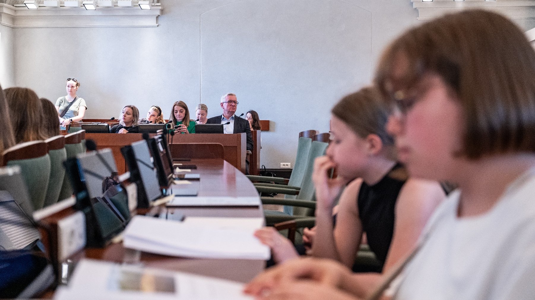 Na zdjeciu dziecięcy radni w sali sesyjnej, w tle prezydent Poznania