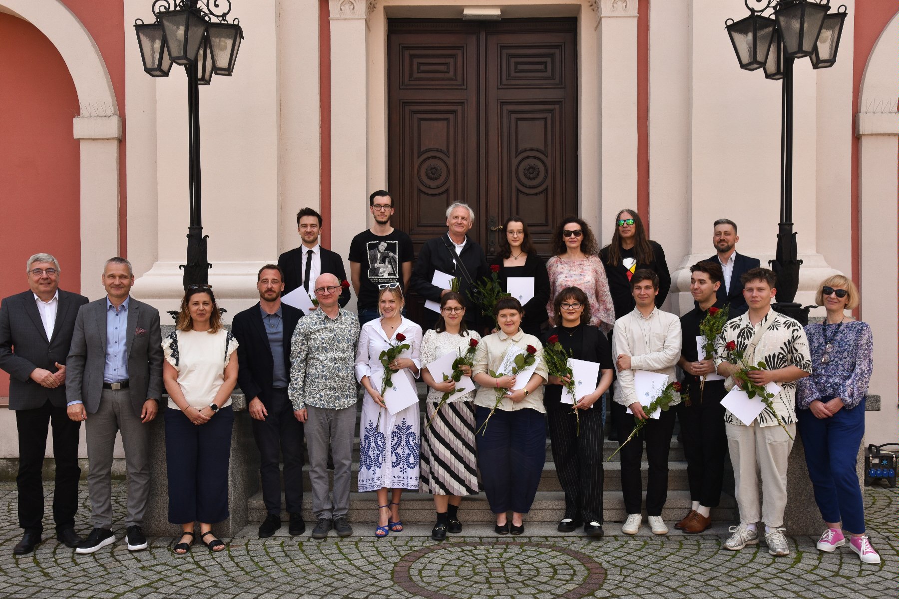 Na zdjęciu grupa ludzi przed urzędem, pozująca do obiektywu - zdjęcie grupowe - grafika rozmowy