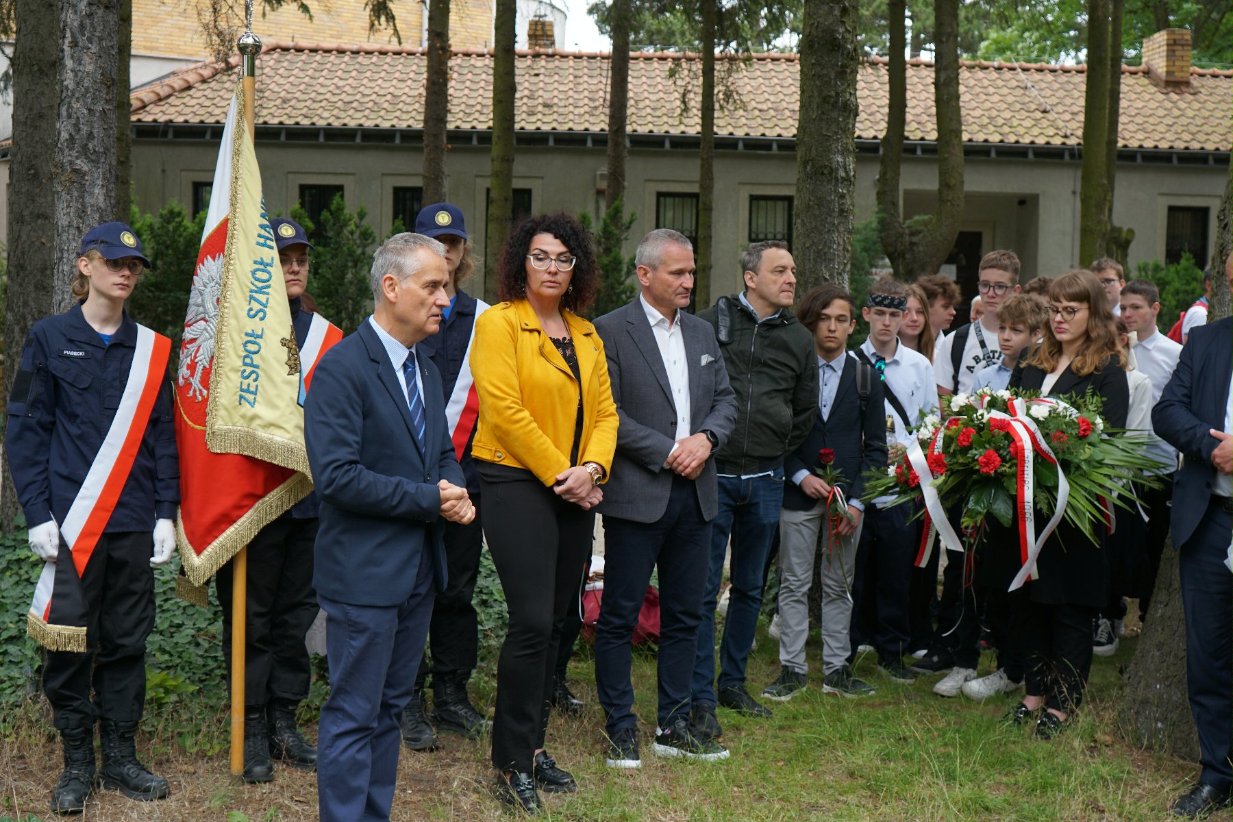 Zdjęcie przedstawia młodziedż i dorosłych na cmentarzu. - grafika rozmowy