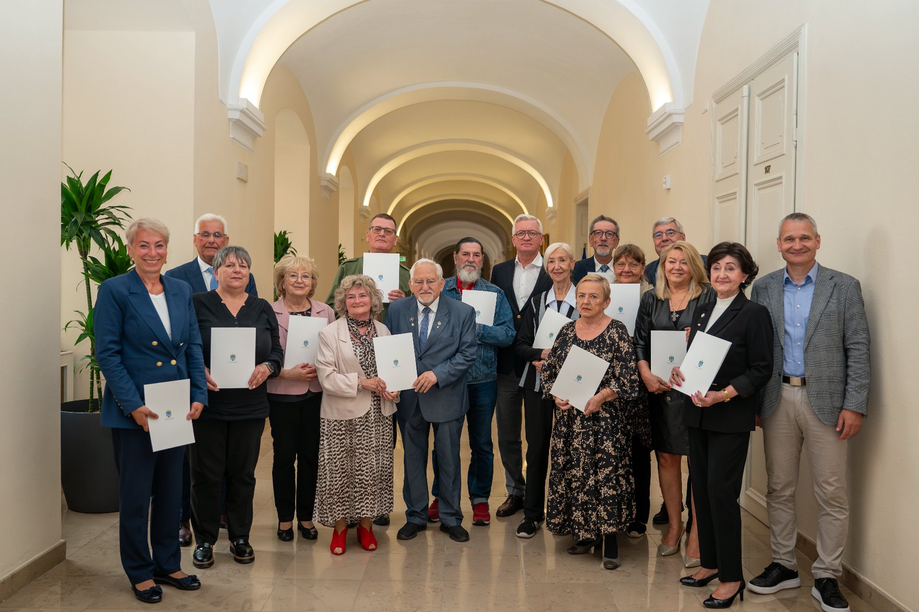 Grupowie zdjęcie senioralnych radnych z przedstawicielami urzędu miasta i rady miasta. - grafika rozmowy