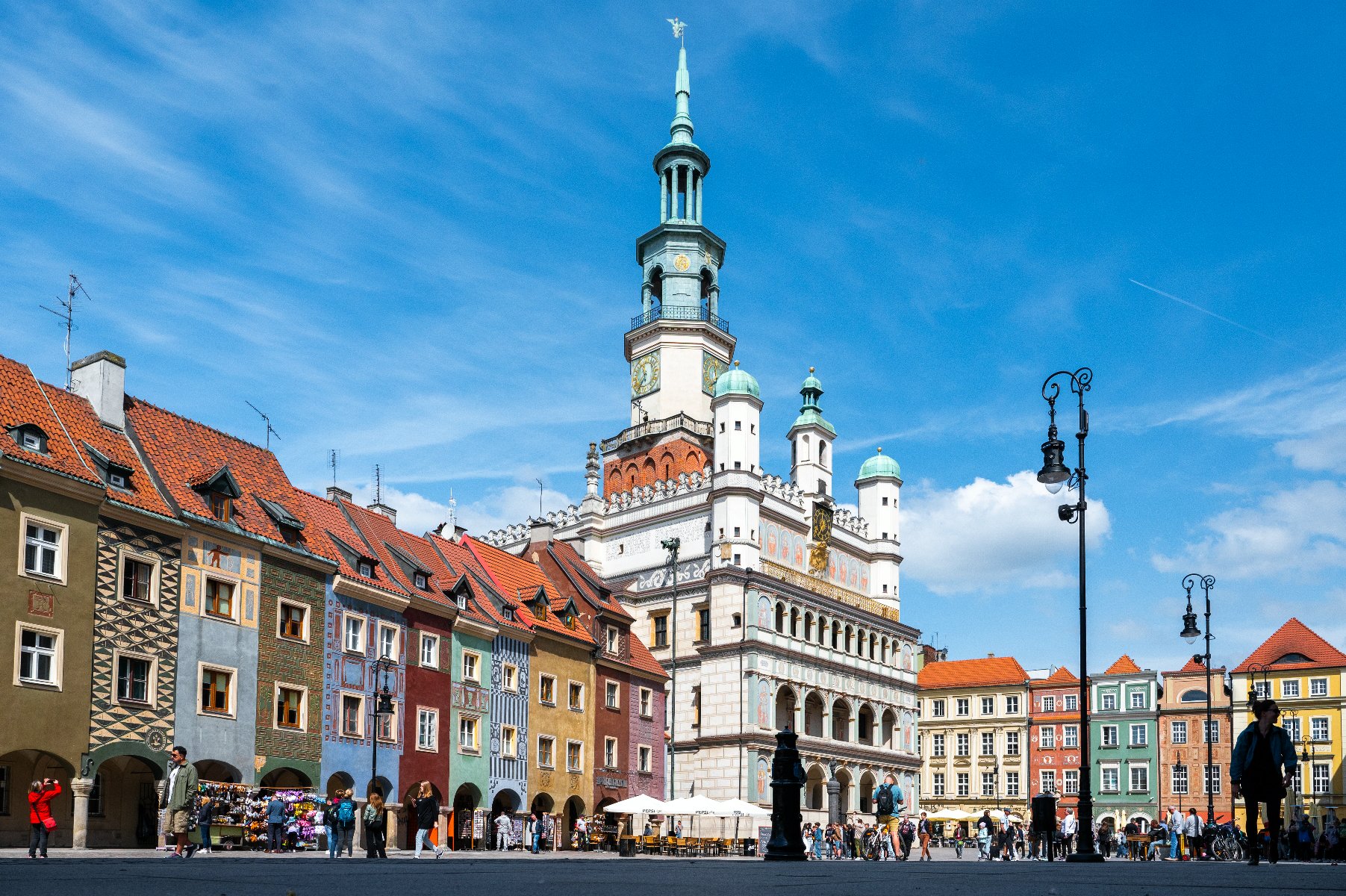 Zdjęcie przedstawia Stary Rynek. Widac na nim tłum ludzi i stoiska z pamiątkami. - grafika rozmowy