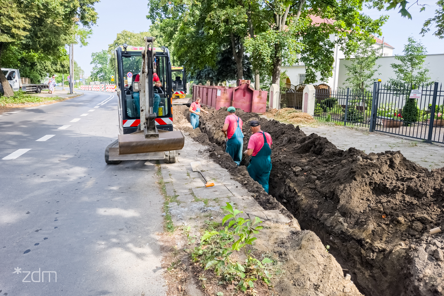 Na zdjęciu robotnicy pracujący przy chodniku - grafika rozmowy