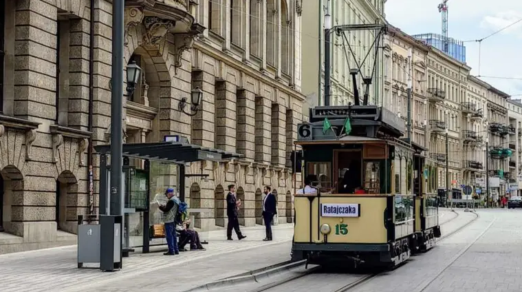 Na zdjęciu zabytkowy tramwaj w centrum miasta - grafika rozmowy