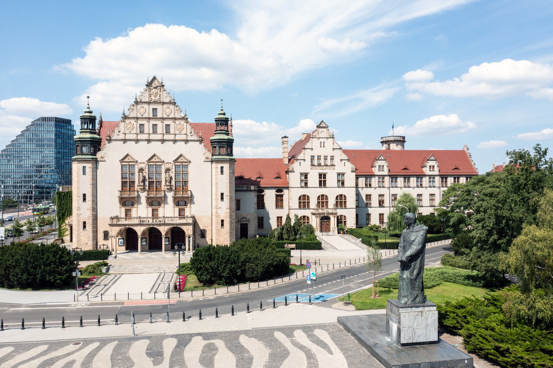 Zdjęcie przedstawia budynek Collegium Minsu UAM wiziany z lotu ptaka. W tle biurowiec Bałtyk. - grafika rozmowy