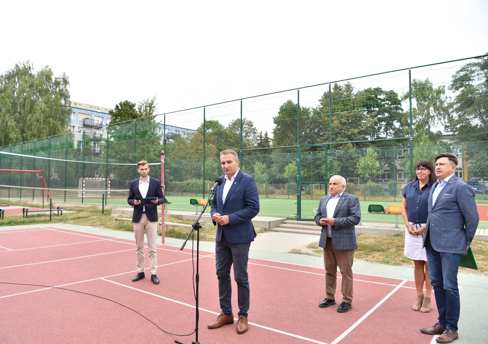 Zdjęcie przedstawia osoby biorące udział w konferencji prasowej na boisku. - grafika rozmowy