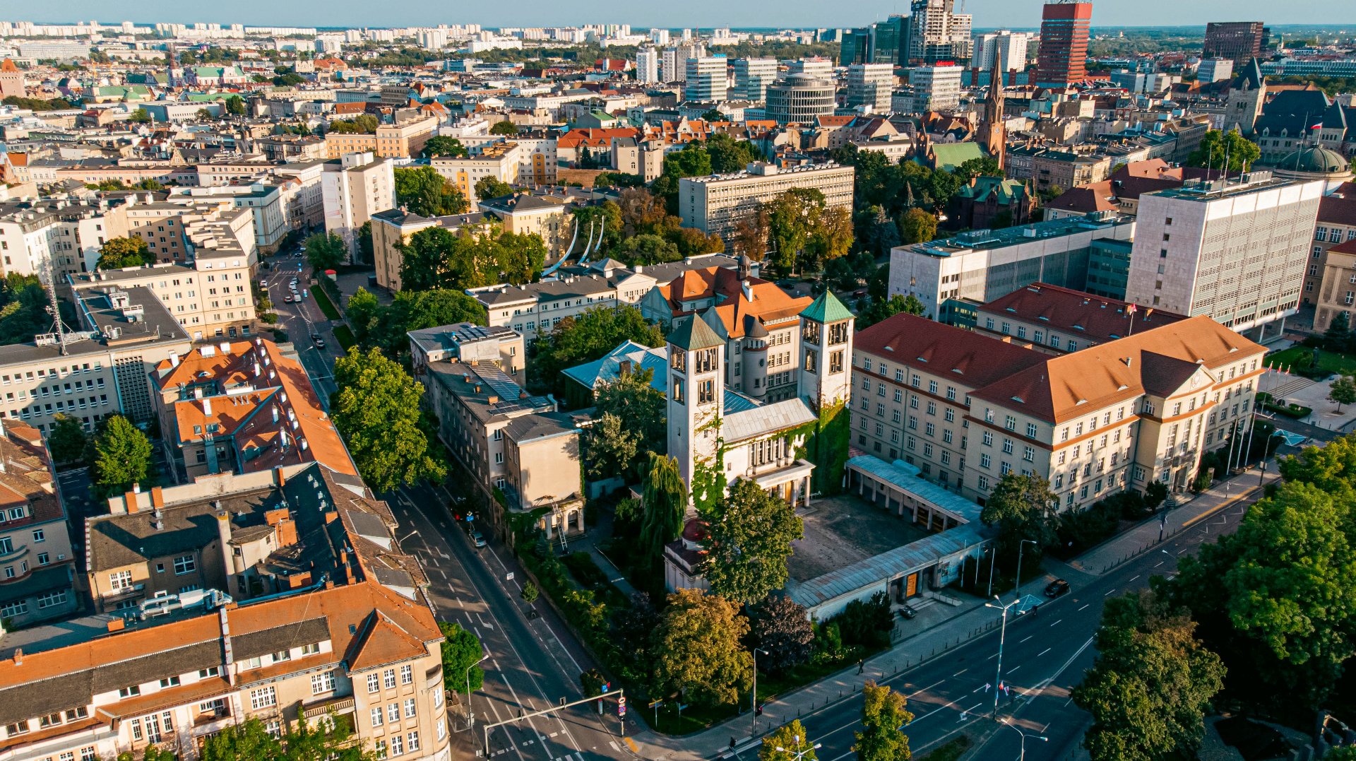 Na zdjeciu Poznań widziany z lotu ptaka, widać dachy kamienic - grafika rozmowy