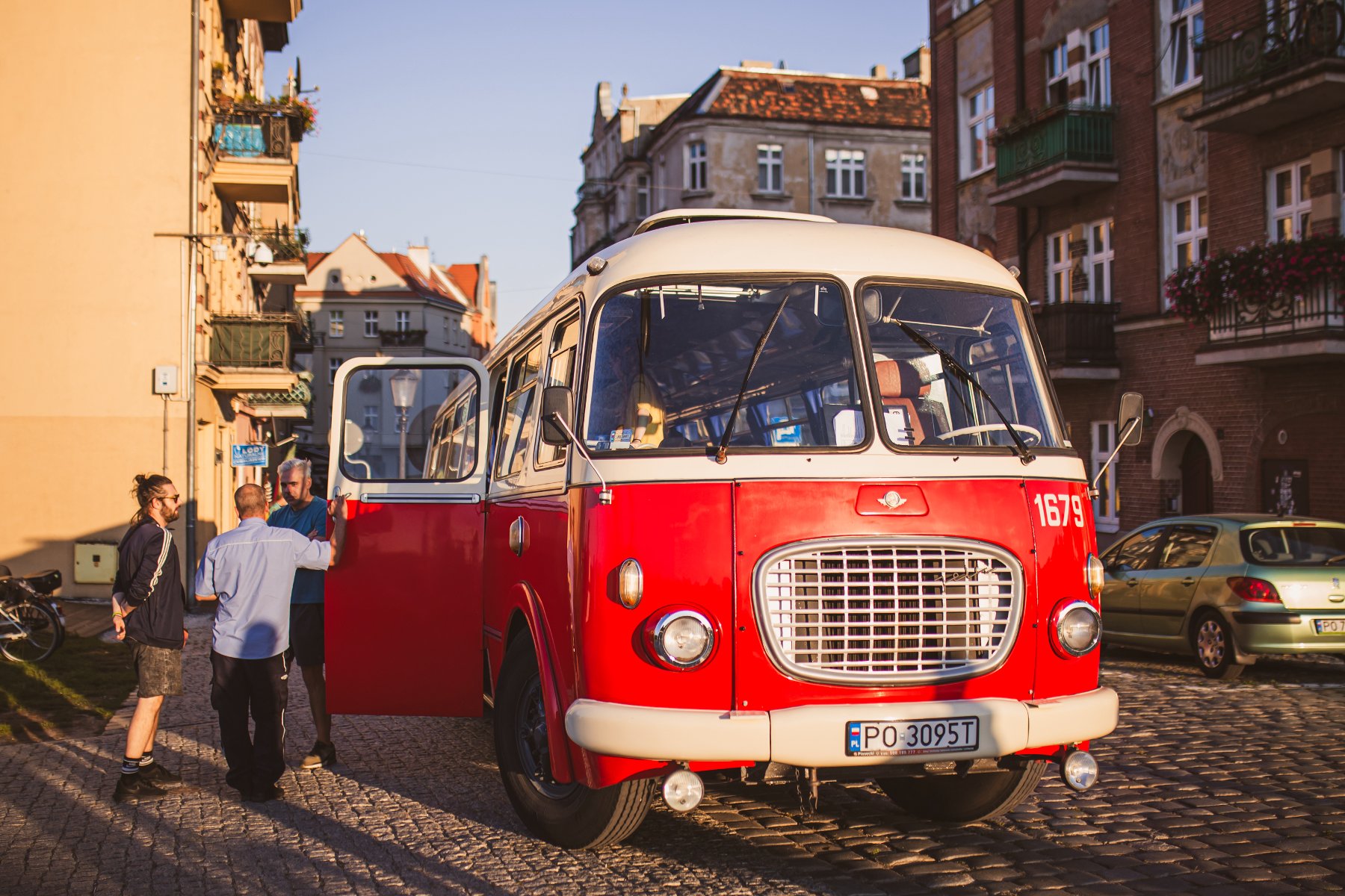 Zdjęcie przedstawia czerwony zabytkowy autobus. - grafika rozmowy