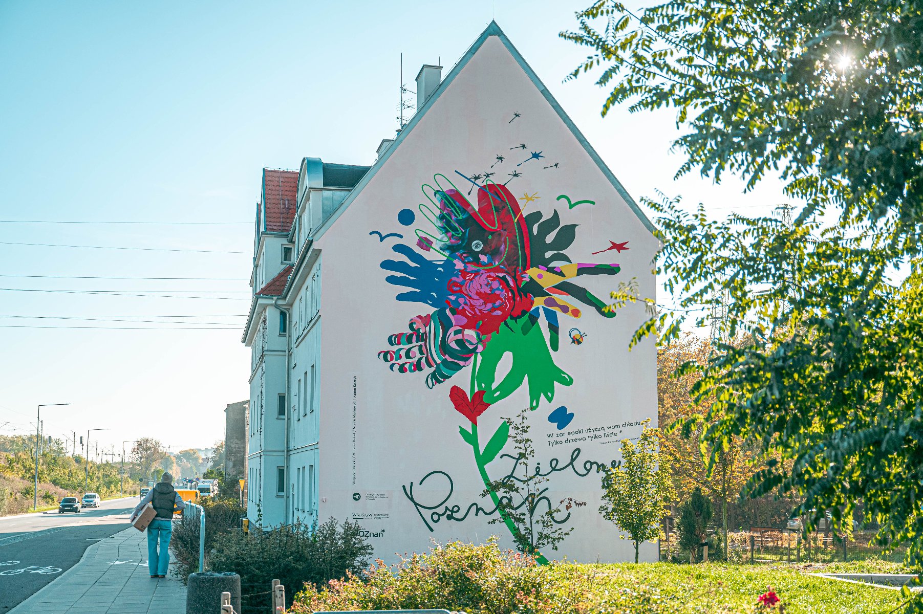 Na zdjęciu kamienica, na jej bocznej ścianie kolorowy mural - splecione dłonie - grafika rozmowy