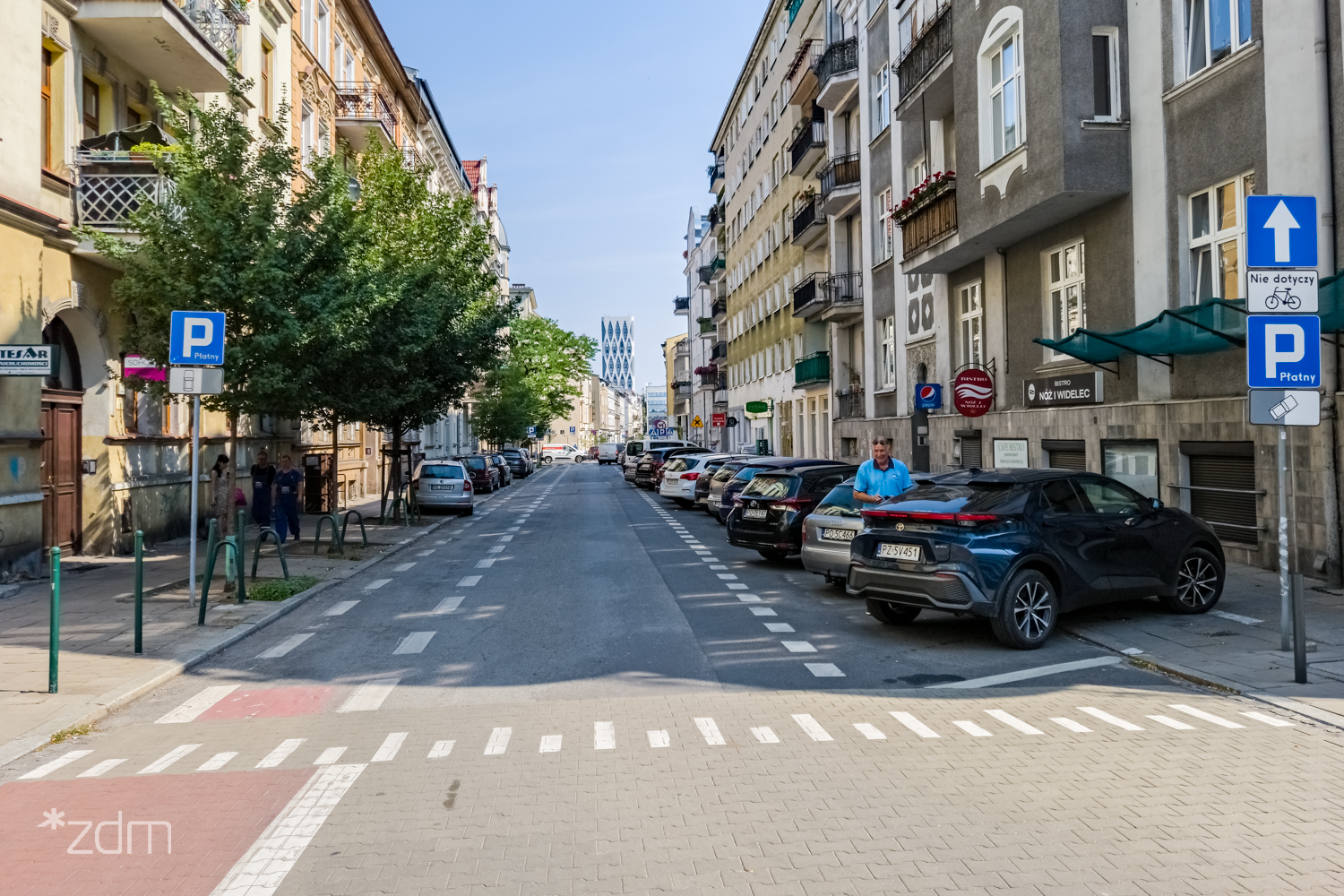 Zdjęcie ulic Wawrzyniaka przed zmianami. Widać samochody parkujące po obu stronach - grafika rozmowy