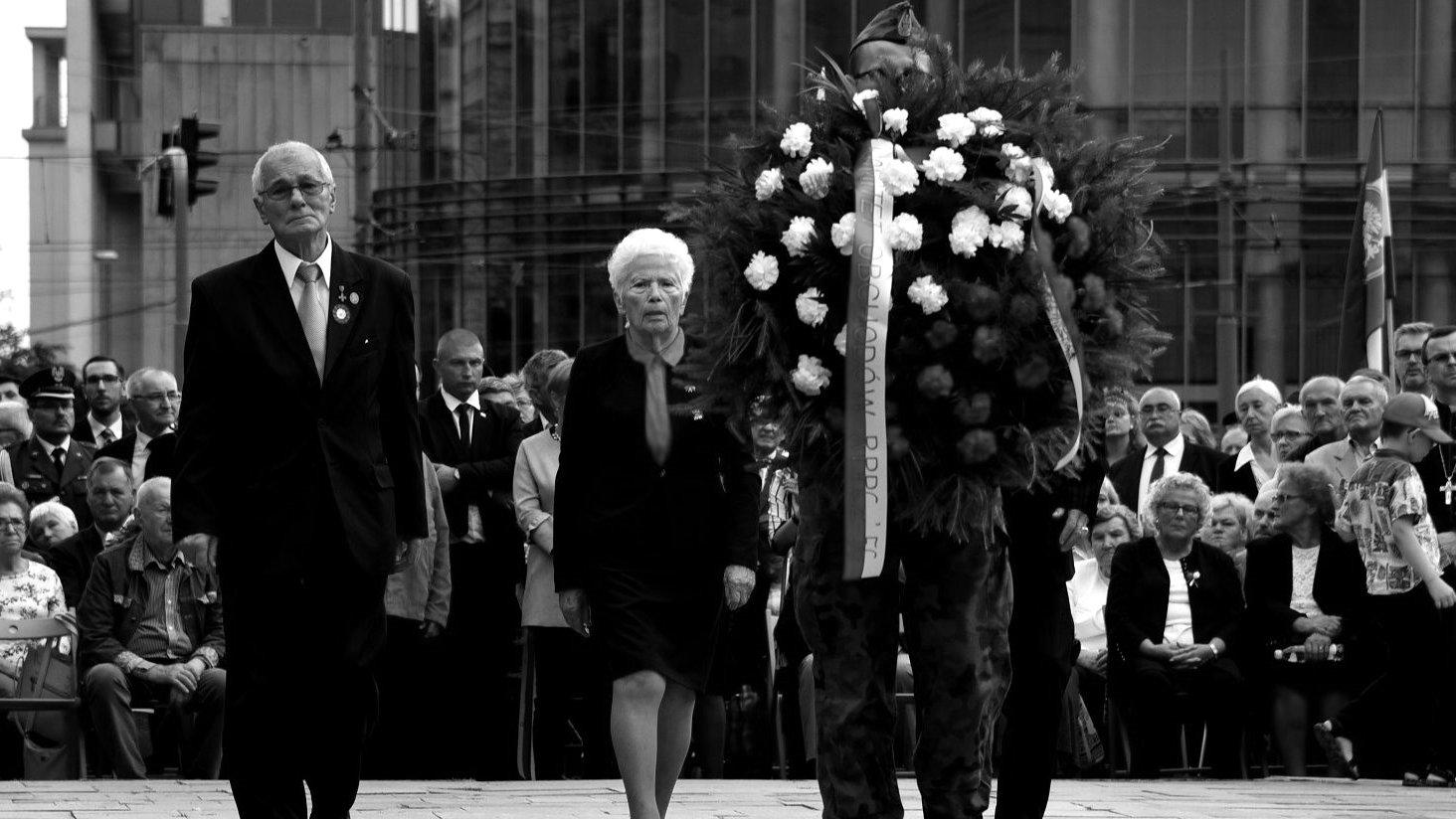 Czarno-białe zdjęcie Jerzego Majchrzaka składającego kwiaty podczas uroczystości Czerwca '56