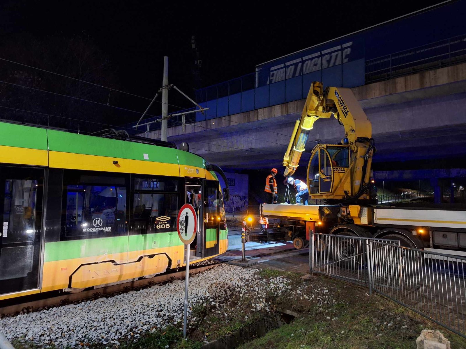 Zdjęcie przedstawia zepsuty tramwaj oraz maszynę i ludzi, którzy będą go holować lub naprawiać. - grafika rozmowy