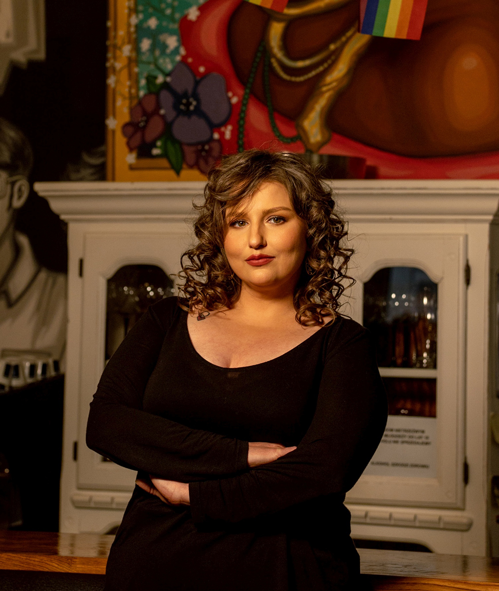 Młoda kobieta w czarnym stroju z długimi kręconymi włosami - grafika rozmowy