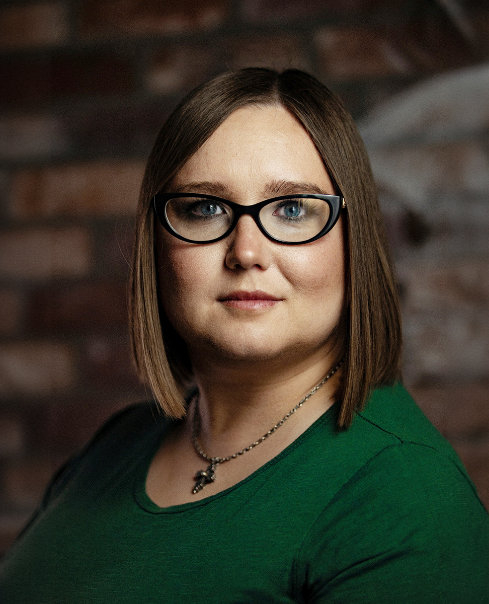 młoda kobieta w okularach, na szyi widoczny krzyżyk - grafika rozmowy