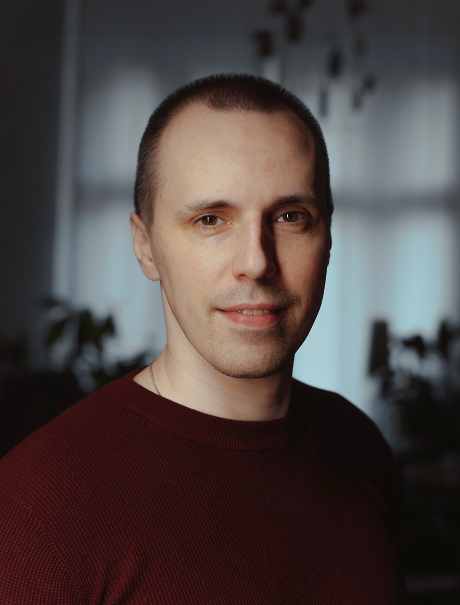 młody mężczyzna w swetrze, z krótko przyciętymi włosami, uśmiechnięty - grafika rozmowy