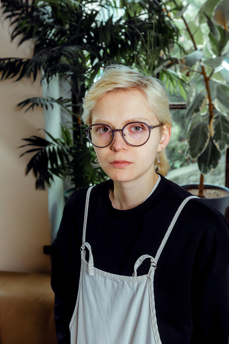 młoda osoba z jasnymi krótkimi włosami, w okularach - grafika rozmowy