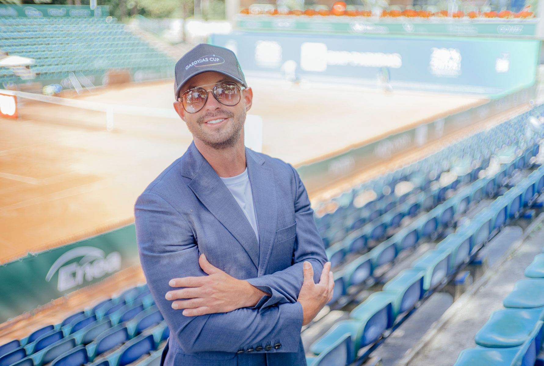 Mężczyzna w czapce z daszkiem i okularach na tle hali sportowej