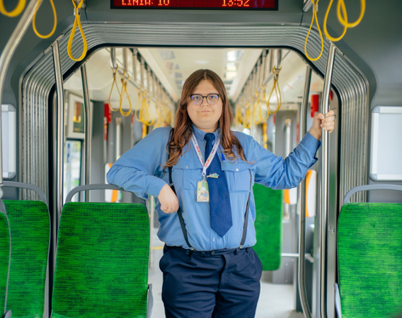 młoda kobieta w stroju motorniczego stoi w tramwaju