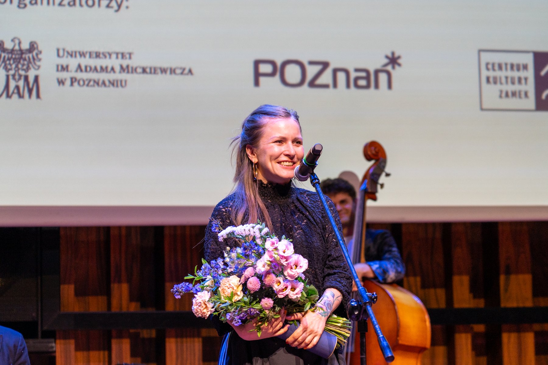 Na zdjęciu uśmiechnięta laureatka, mówiąca coś do mikrofonu
