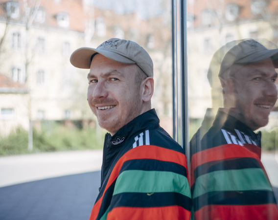 Uśmiechnięty mężczyzna w czapce z daszkiem i sportowej kurtce